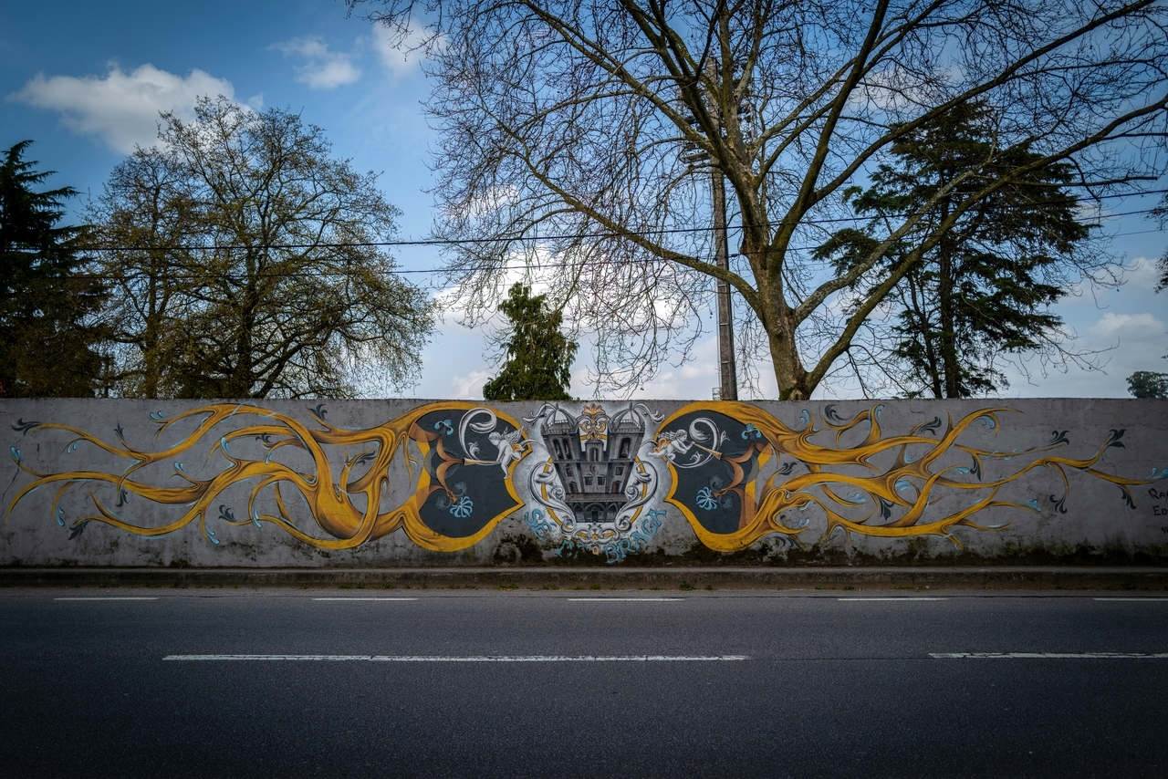 In 2017, a group of young artists, predominantly from Braga, carried out a set of interventions, within the scope of mural painting, allusive to the most referenced and classified local Heritage. The interventions took place on the outer walls of the Braga Campsite and the themes were distributed according to the location axis of the Heritage represented. In this case, it is the wall facing the National 101 and the Sé de Braga (Braga Cathedral) is represented.