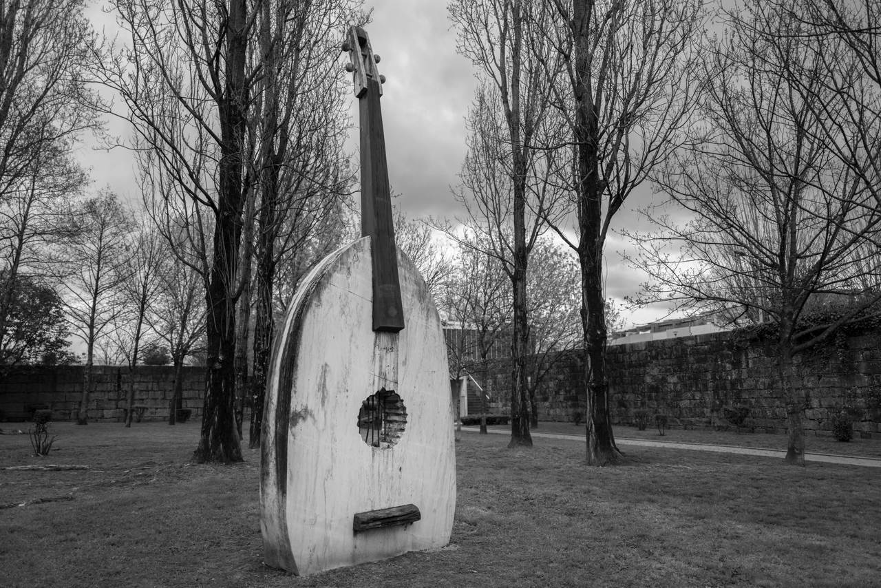 This sculptural element, in marble, represents a Portuguese guitar, in marble and vertical, and is evocative of one of the symbols of the national musical tradition, despite having been designed by an artist from Galicia (Spain).