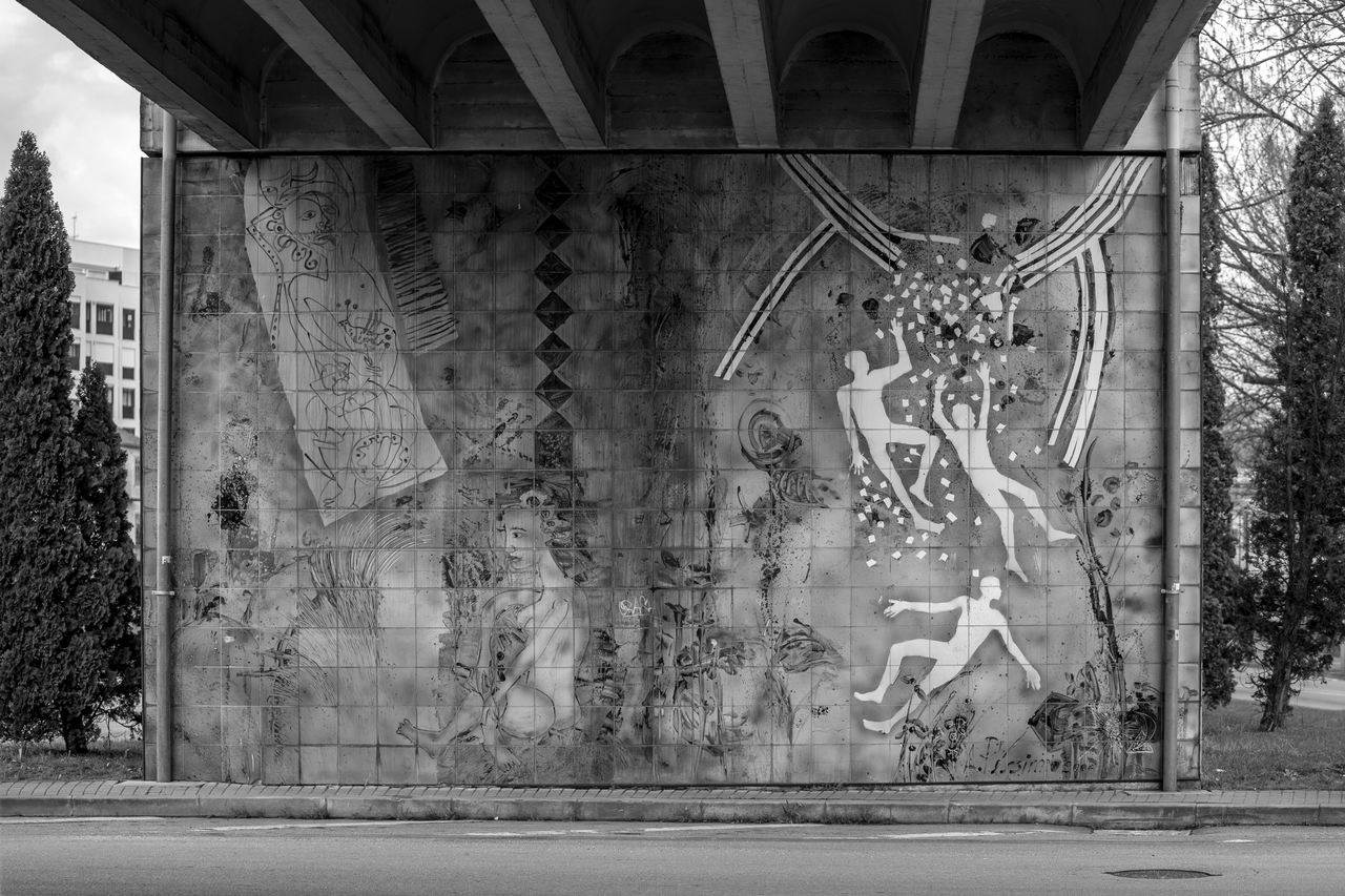 The double tile panel was offered by the dstgroup to the city upon completion of this roundabout/viaduct and is by Alberto Péssimo, an artist from Braga who dedicates himself to painting, fundamentally, in various media, in which tiles are included.  The work reflects the expressionist nature, the free gesture, and the preference for an austere figuration of this author.