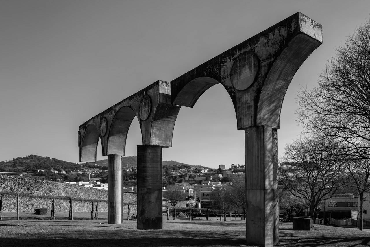 Monument Commemorating the Bimillenary of the City of Braga, it marks the foundation of Bracara Augusta and is located on Colina da Cividade, a place dominated by Roman remains.  
Made of concrete, it represents the Roman aqueduct and consists of three round arches, supported by three pillars, which have an intentional irregular structure.