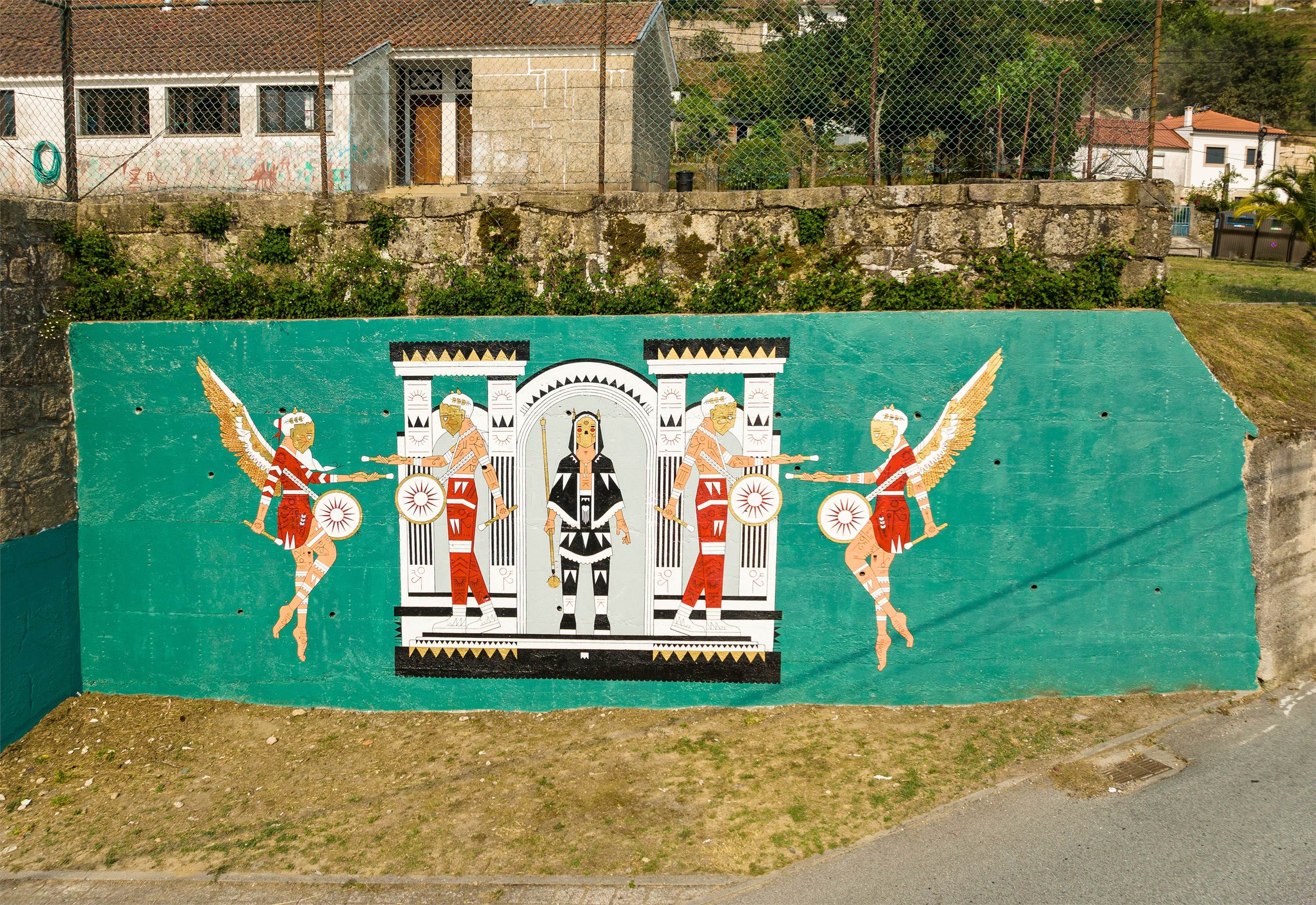 14.07.2022
Inspirada no Carnaval de Vilarinho, a obra tenta transportar para a parede os sons e as sensações vividas no mesmo. O som e a energia dos bombos, que ecoam pela freguesia à medida que o cortejo avança pelas ruas, têm um grande destaque na obra, pois é no som dos mesmos que é gerada toda a energia e vibração contagiosa do Carnaval de Vilarinho. No centro a representação de um Careto, conhecidos por serem uns “diabretes” durante o Carnaval, pois são eles os reis das partidas e das traquinices, sendo também o som dos bombos o aviso da sua chegada.